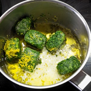 thawing spinach in a pot with butter and lemon