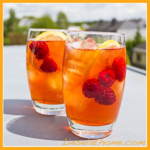 two glasses of ice tea with lemon and raspberries