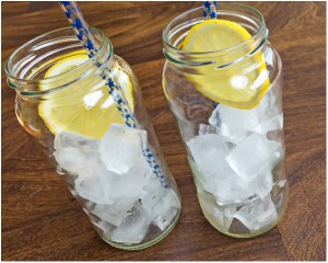 two mason jars with ice cubes and lemon