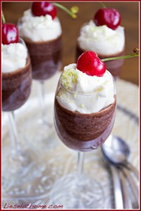 chocolate dessert with whipped cream, cherries and green coconut sprinkles